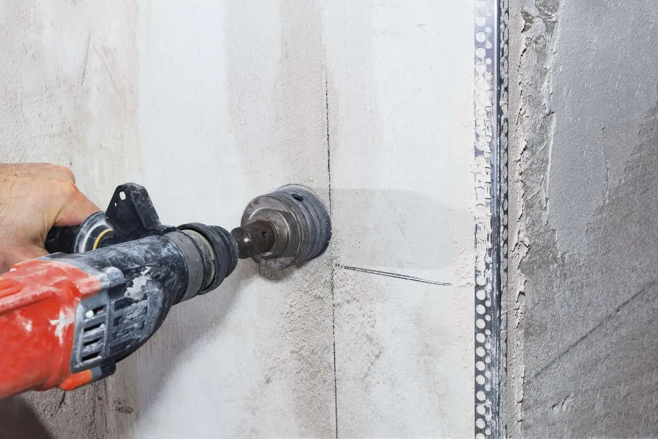 Perfuratriz executando furo em parede de concreto